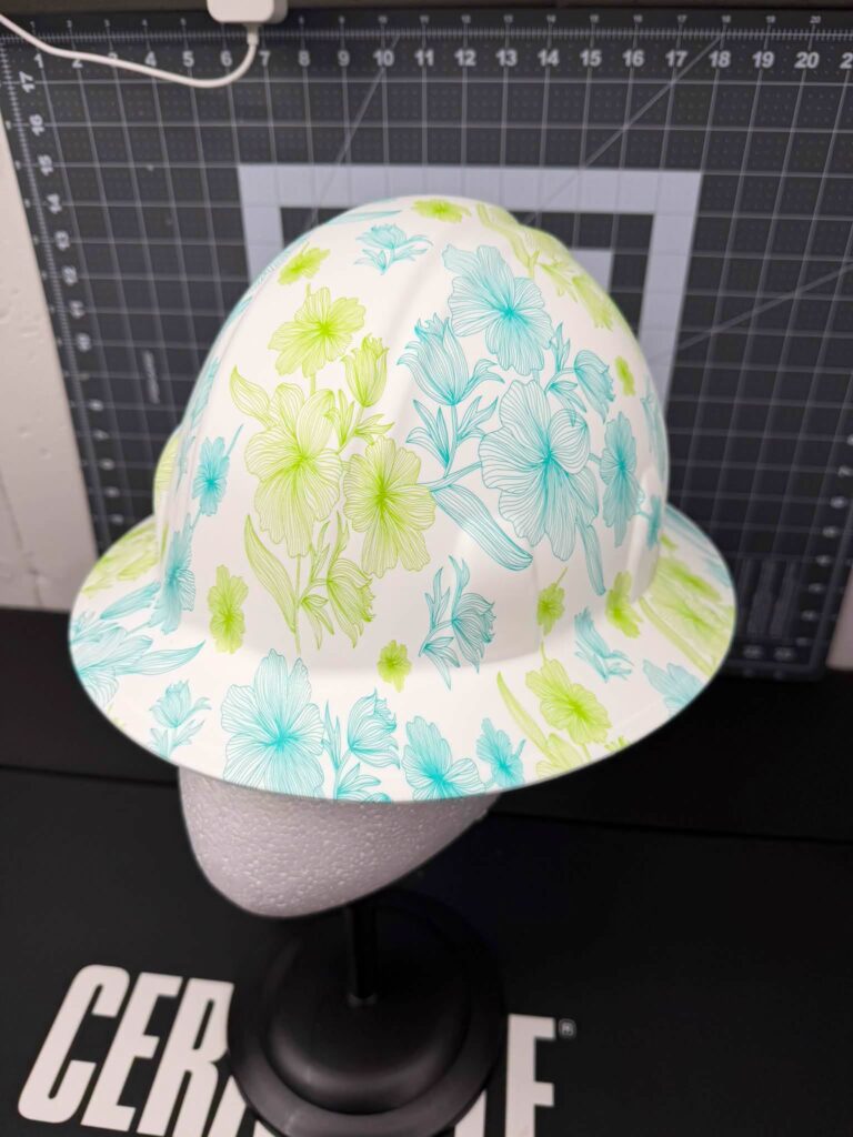 Full-brim hard hat finished in a teal and green floral hydrographic film
