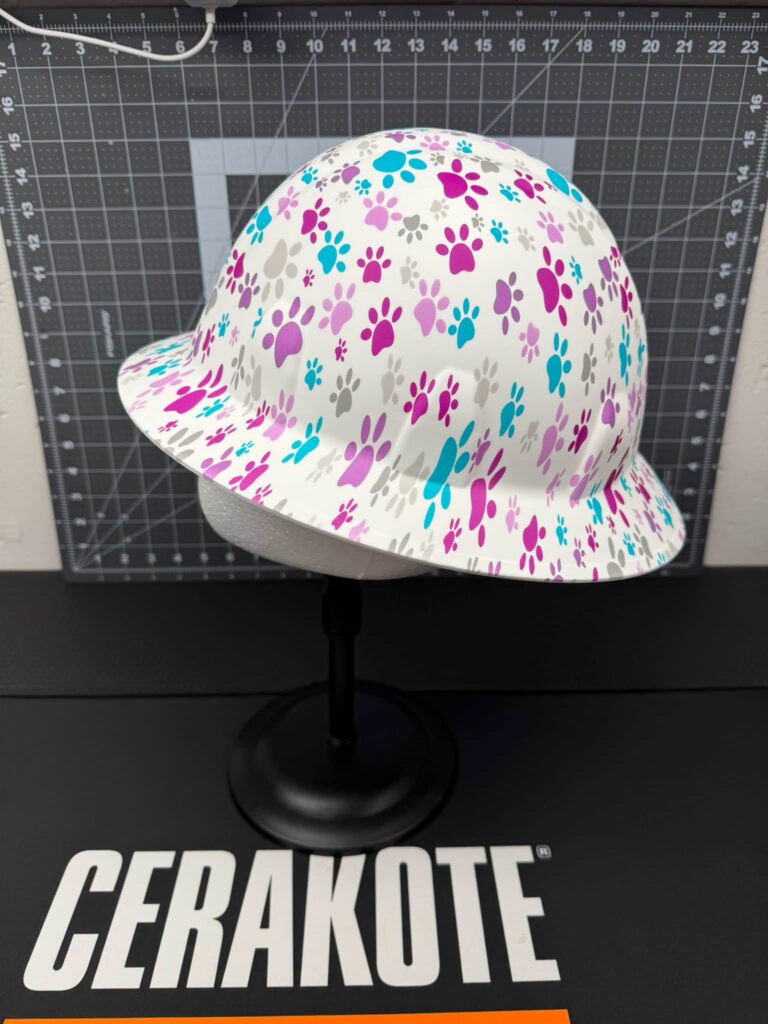 Cap-style hard hat finished in a pink, purple and blue paw print hydrographic film